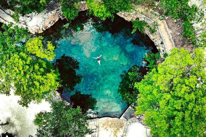Cenote de cueva con aguas cristalinas en la selva de la Riviera Maya