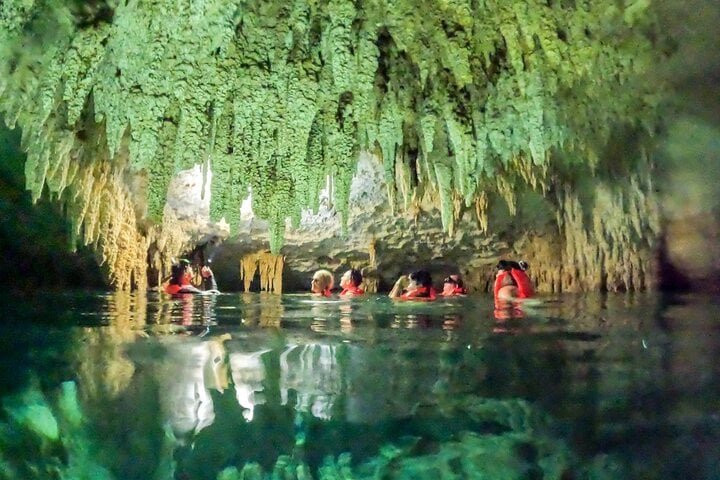 Pareja disfrutando snorkel en un cenote de cueva de forma privada